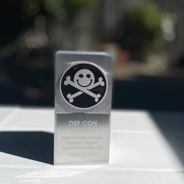 Image of award outside, silver brick with DEF CON logo.